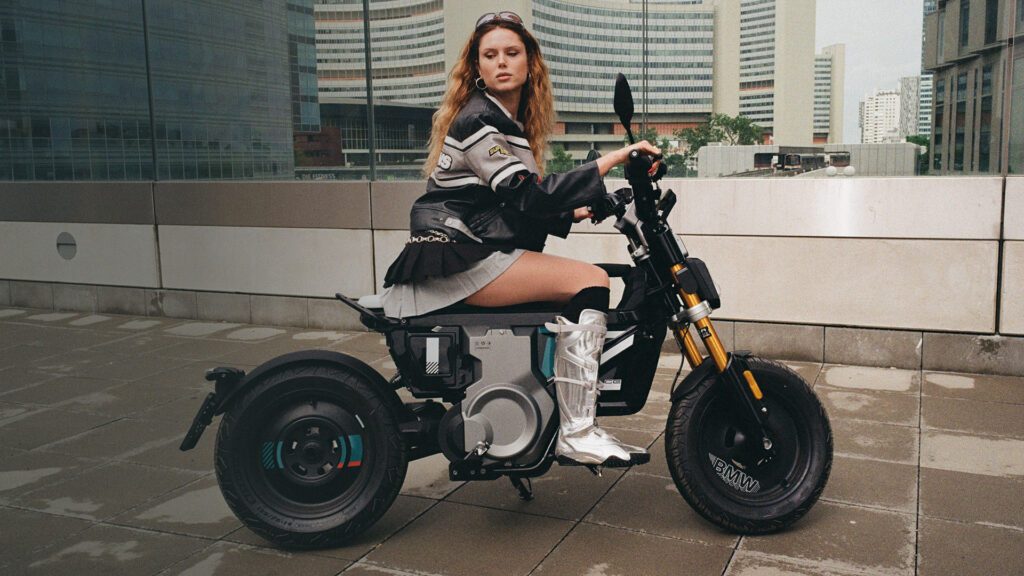 Eli Preiss auf dem vollelektrischen BMW CE 02 vor urbaner Skyline als Key Visual der Digitalkampagne
