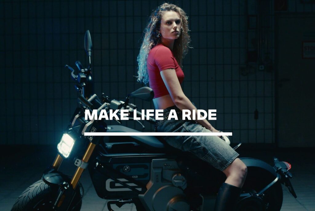 Eli Preiss sitzt in beleuchteter Szene auf E-Motorrad mit BMW Slogan 