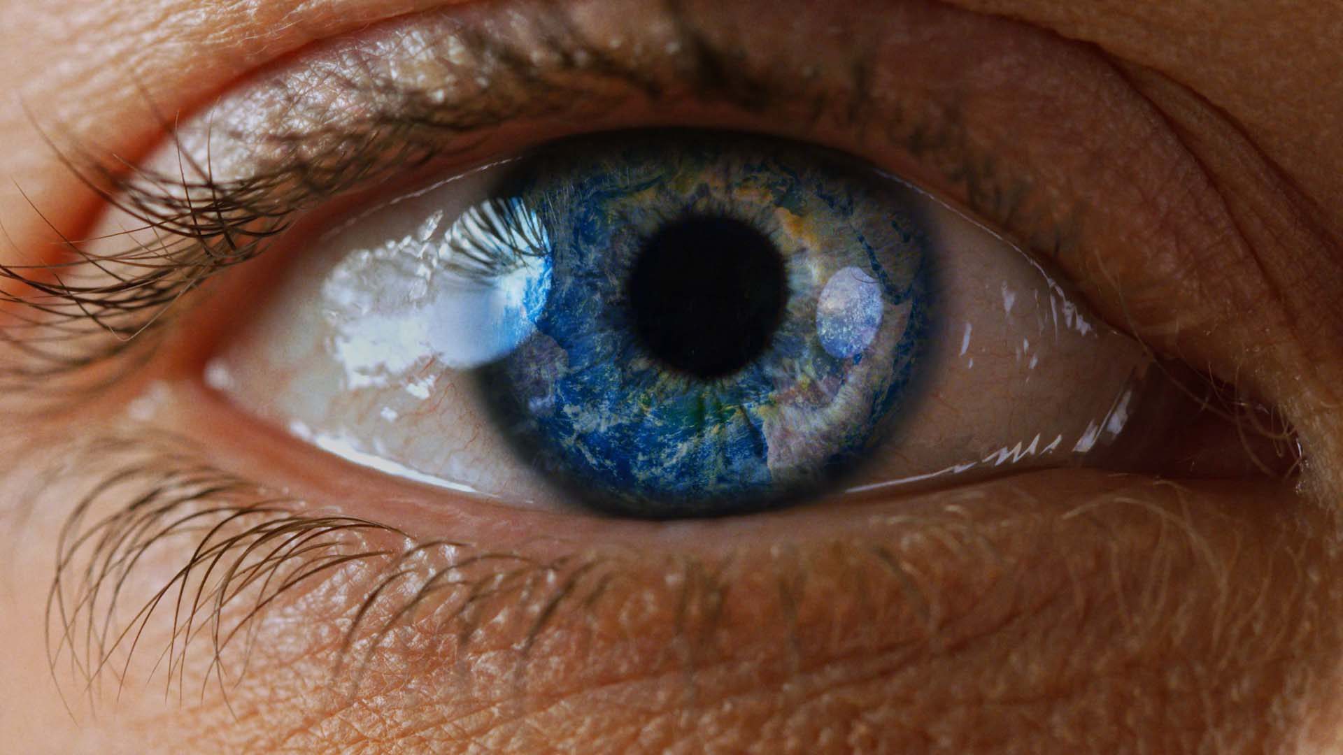 Makroaufnahme eines Auges mit reflektierendem Lichtmuster aus dem Imagefilm für amsOSRAM produziert von Wuger zur Darstellung von Sensorik Präzision und Lichttechnologie