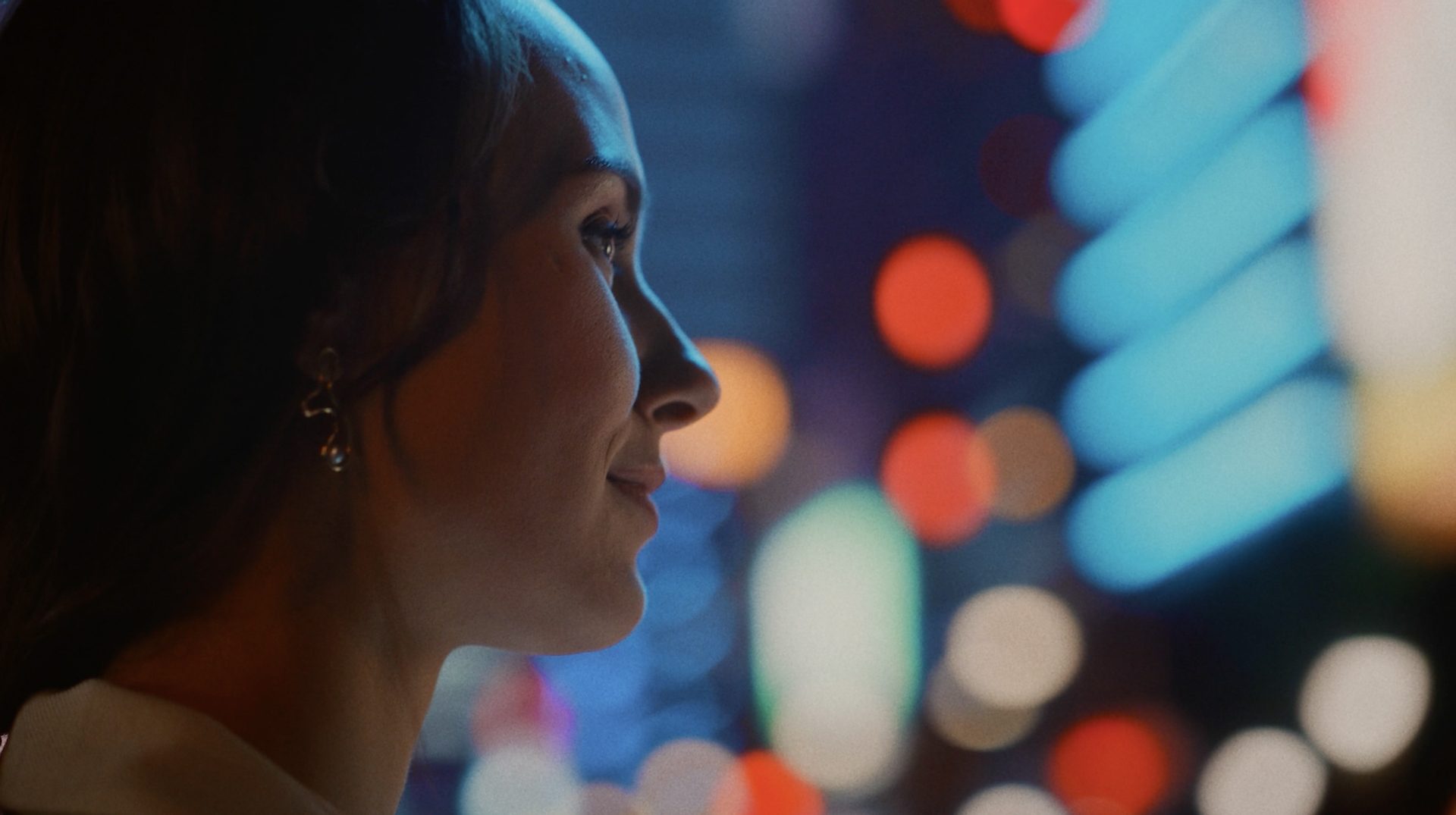wuger-case-aNahaufnahme einer Frau im Lichtspiel einer Stadt bei Nacht aus dem Imagefilm für amsOSRAM produziert von Wuger als Teil der Markenkommunikation zu Licht und Technologiemsosram-imagefilm-frau-2