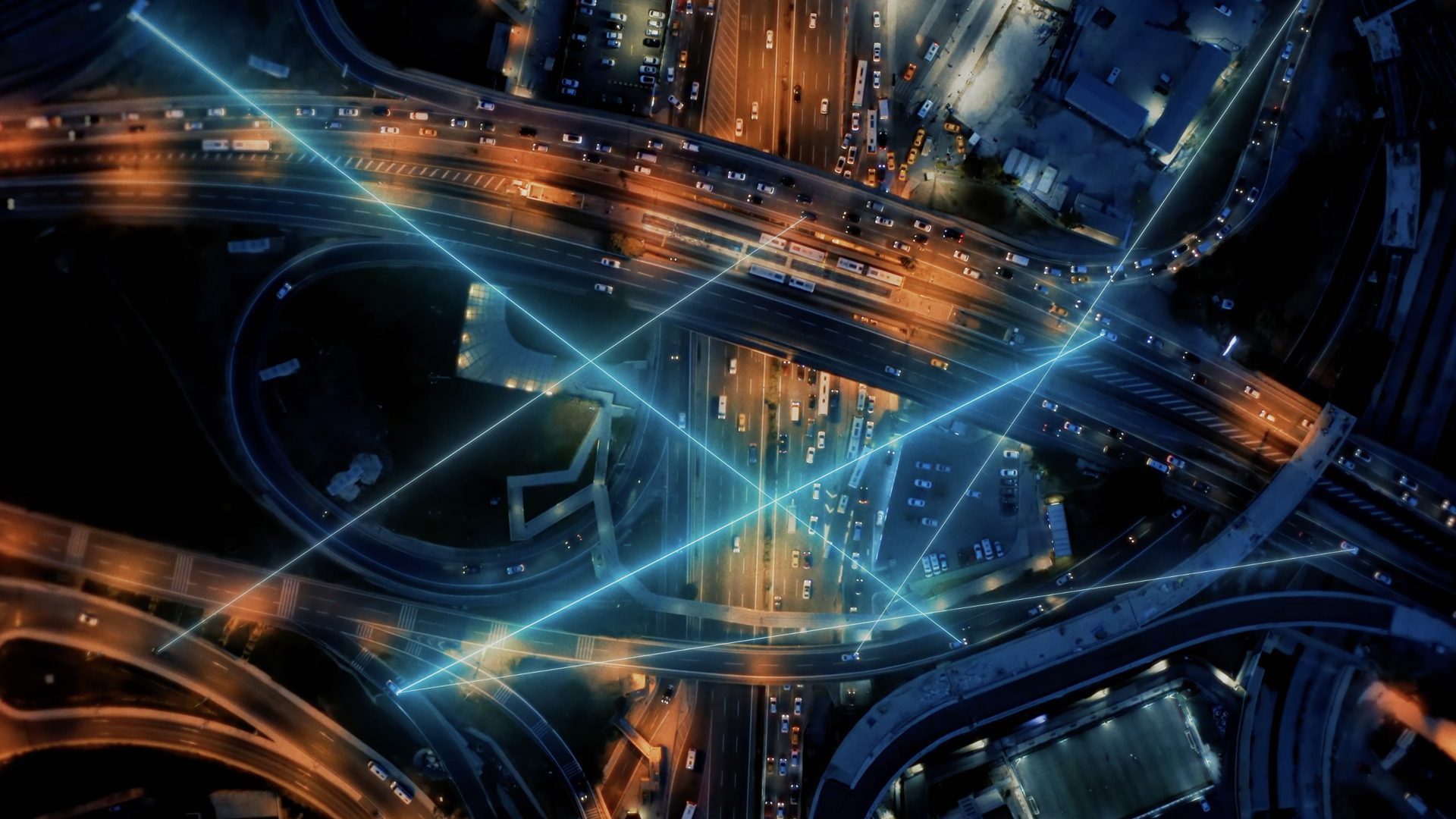Luftaufnahme einer nächtlichen Stadt mit vernetztem Straßenverkehr und Lichtlinien aus dem Imagefilm für amsOSRAM produziert von Wuger zur Visualisierung von Technologie und intelligenter Beleuchtung.