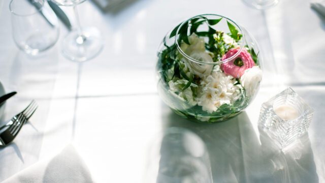Tischdekoration mit Blumen und Kerze im Restaurant Brunnauer, Teil unseres Corporate Design Gastronomie Projekts für Ambiente und Markenidentität