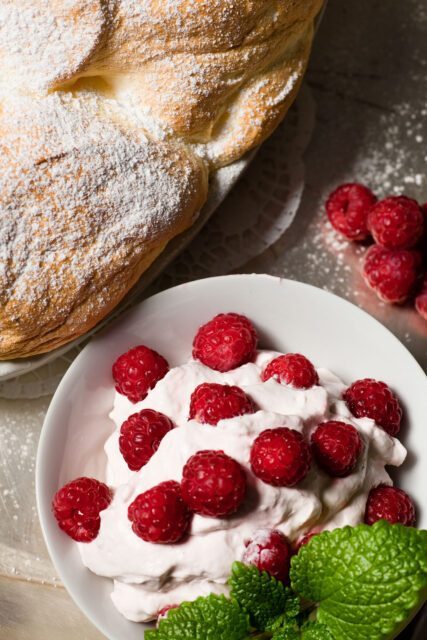 Traditionelles Salzburger Nockerl mit Puderzucker und frischen Himbeeren auf Sahne, fotografiert für unser Gastronomie Branding Projekt bei Wuger Hospitality