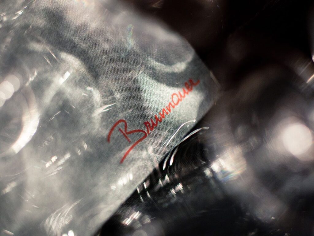 Serviette mit rotem Brunnauer Schriftzug umgeben von Gläsern, fotografiert für unser Corporate Design Gastronomie Projekt und die Markenidentität des Restaurants