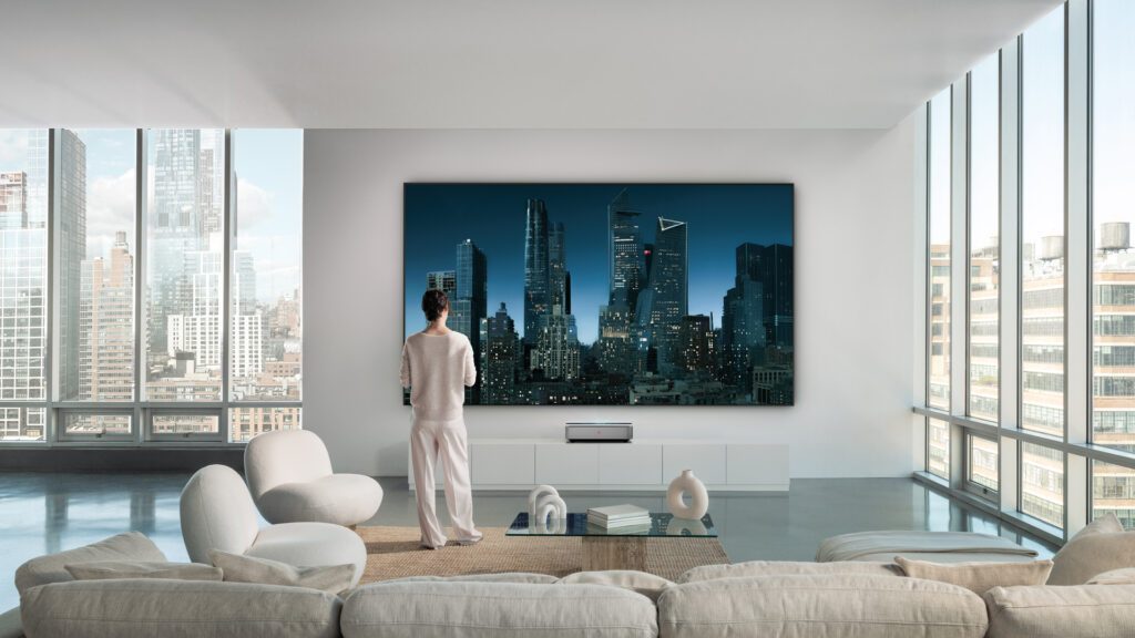 Eine Person betrachtet die nächtliche Skyline von New York, projiziert vom Leica Cine 1 in einem modernen, hellen Loft. Markeninszenierung von WUGER.