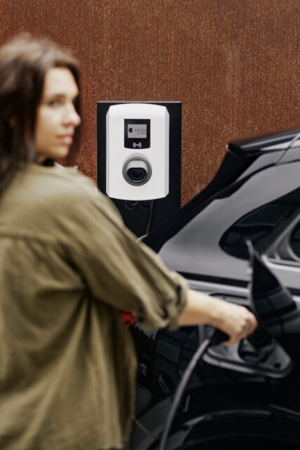 Frau lädt Elektroauto an MOON Wallbox, Markenrelaunch Elektromobilität von Wuger