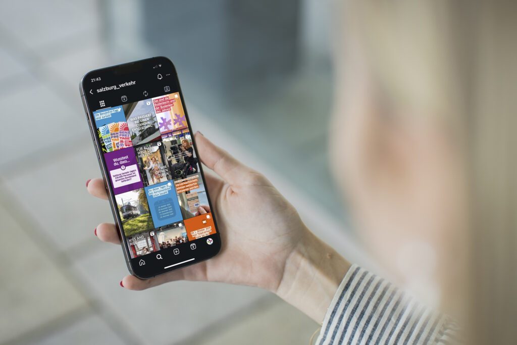 Person hält Smartphone mit dem Instagram-Feed von Salzburg Verkehr und scrollt durch vielfältigen Social Media Content