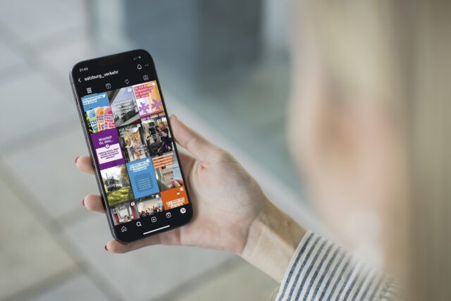 Ein Social Media Auftritt, der Information, Community und regionale Nähe sichtbar macht. Person hält Smartphone mit dem Instagram-Feed von Salzburg Verkehr und scrollt durch vielfältigen Social Media Content