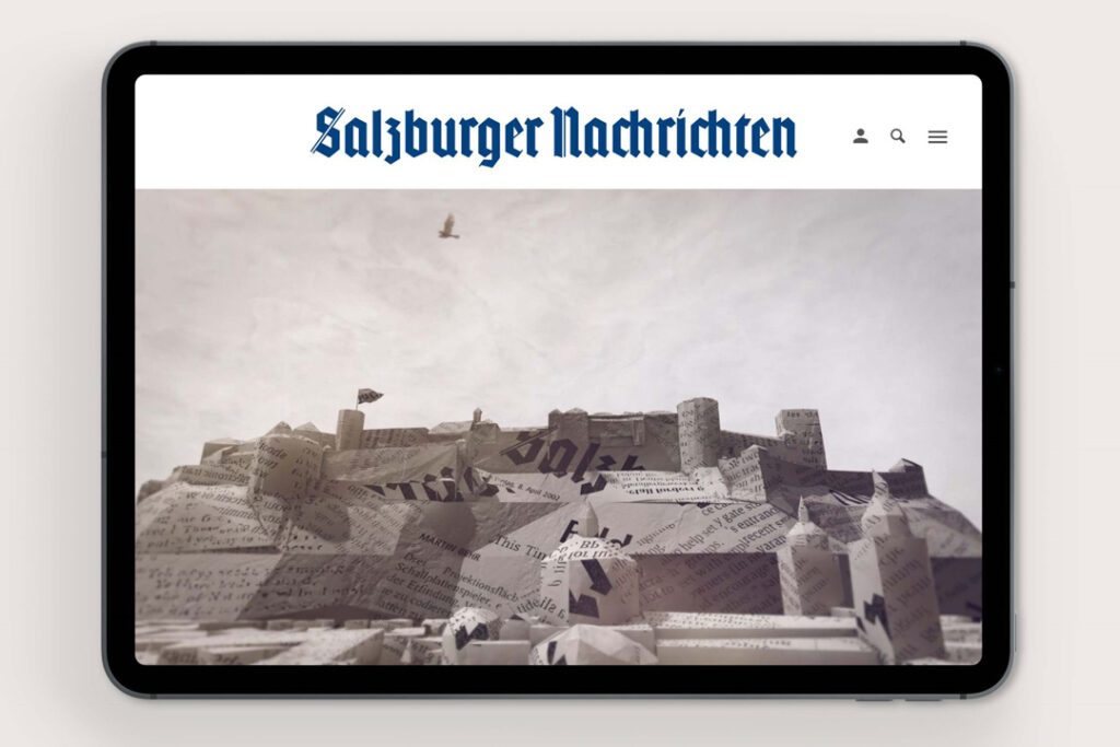 Tablet mit digitalem 3D Motiv einer aus Zeitungspapier geformten Stadtlandschaft