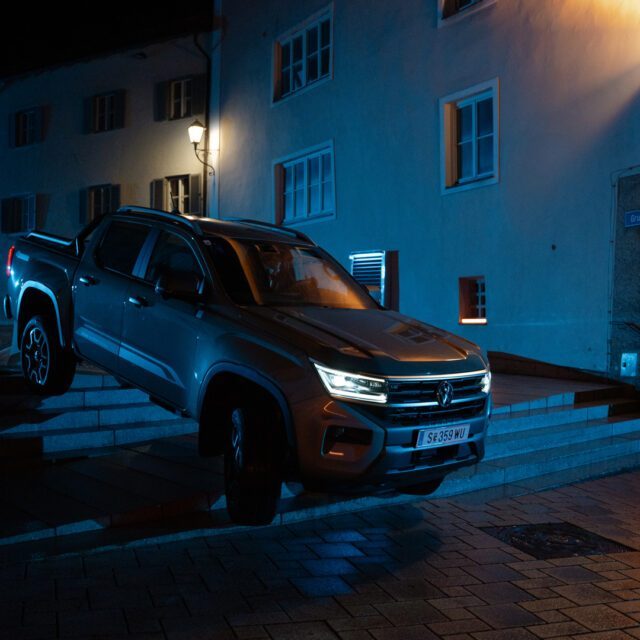 Dynamische Fahrzeuginszenierung für starke Bilder in der Automobilwerbung. Pick-up auf Stufen vor nächtlicher Häuserkulisse, mit markanter Lichtsetzung als Teil einer automobilen Werbespot-Produktion