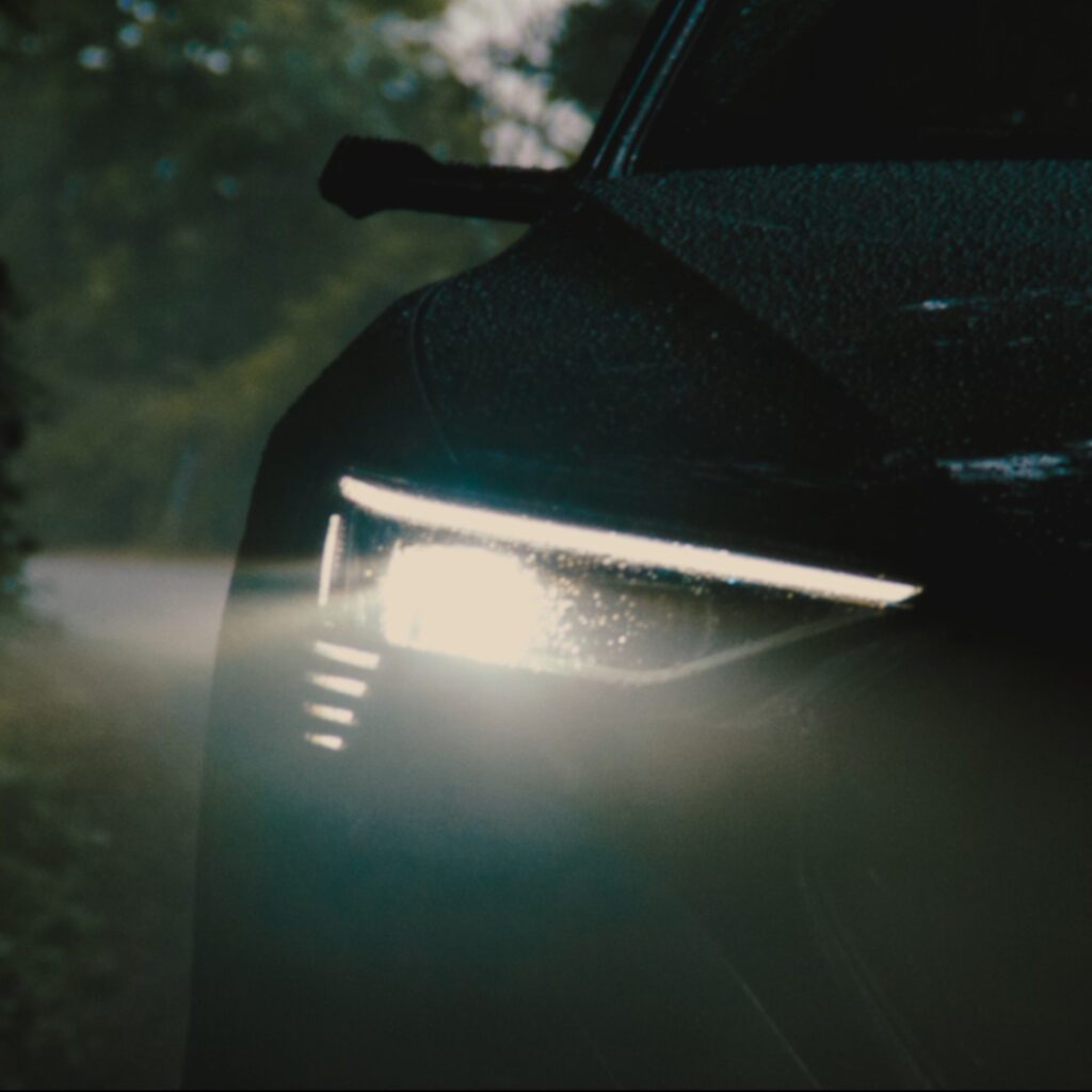 Frontscheinwerfer eines Audi bei Regen im MOON TV Spot mit stimmungsvoller Lichtinszenierung