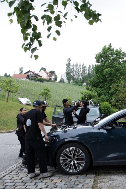 Filmteam bei der TV Spot Produktion für MOON am Weingut Polz mit Kameraaufbau und Fahrzeug im Einsatz