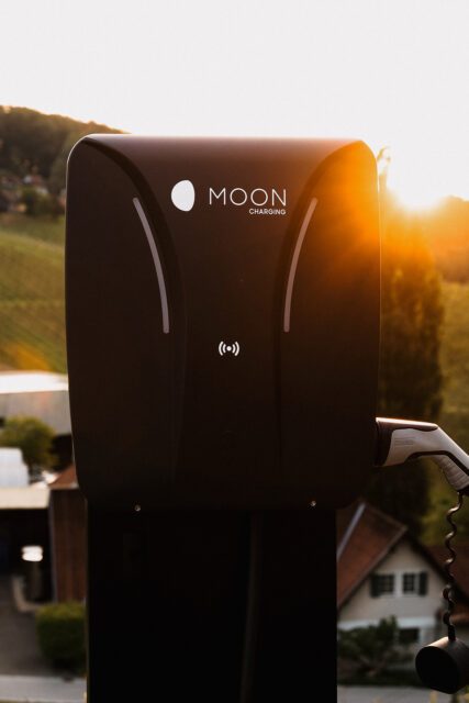 MOON Ladesäule bei Sonnenuntergang mit Blick auf Weinberge und Gebäude des Weinguts Polz