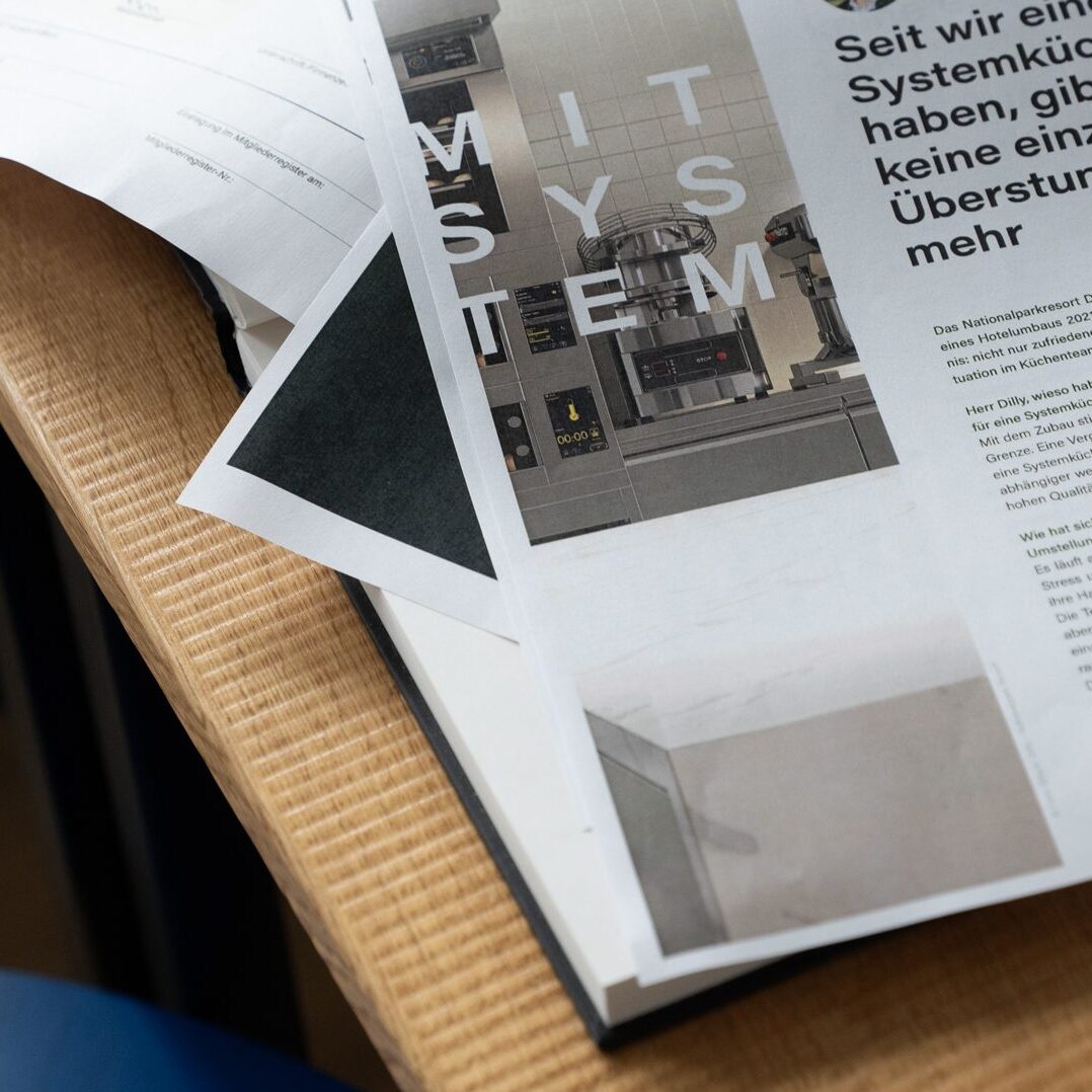 Wuger entwickelt präzise Layouts die Inhalte strukturieren und Marken durch klares Design sichtbar machen. Layoutentwurf mit gedruckten Seiten und Typografie als Teil des Grafikdesign Prozesses bei Wuger