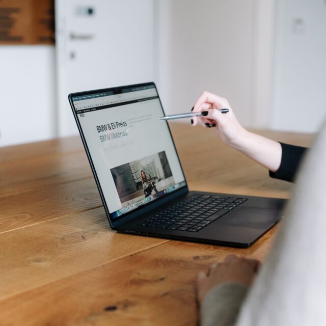 Wuger berät, welche Digitalstrategie die richtige für deine Marke ist. Person zeigt auf Webauftritt einer Marke auf Laptop, um die Digitalstrategie zu besprechen