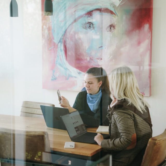 Austausch über digitale Ziele und Inhalte. Wuger Team bespricht digitale Inhalte am Laptop und Smartphone als Teil der Entwicklung einer Digitalstrategie