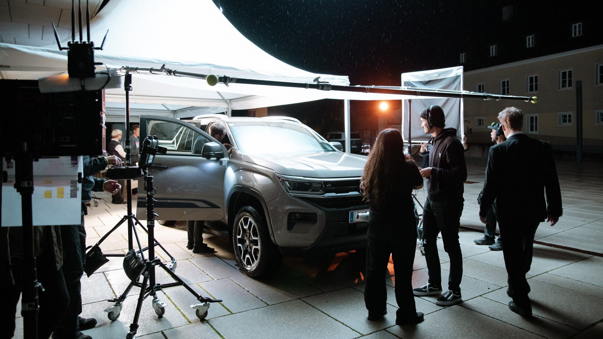 Wuger ist für jede Situation ausgestattet. Filmteam der Agentur Wuger arbeitet nachts an Autoaufnahme mit Lichtsetup und Kameraequipment bei professionellem Set