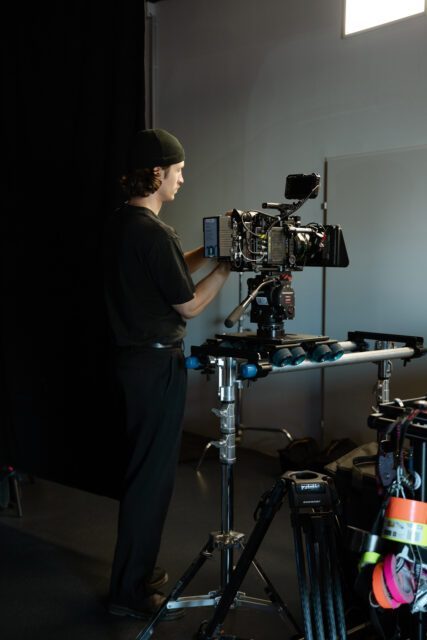 Equipment? Kein Problem. Filmteam? Das Beste. Die Shots? Einzigartig. Kameramann von Wuger richtet Filmkamera am Set der Filmproduktion