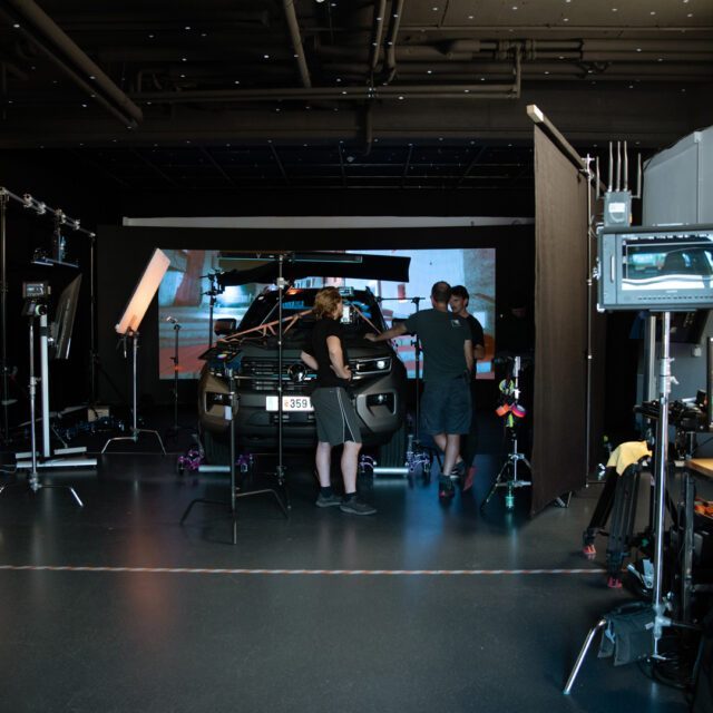 Am Filmset koordinierte das Team Licht, Kamera und Setaufbau. Wuger Team Arbeitet am Filmset für einen Automobilspot und stimmen Licht ab