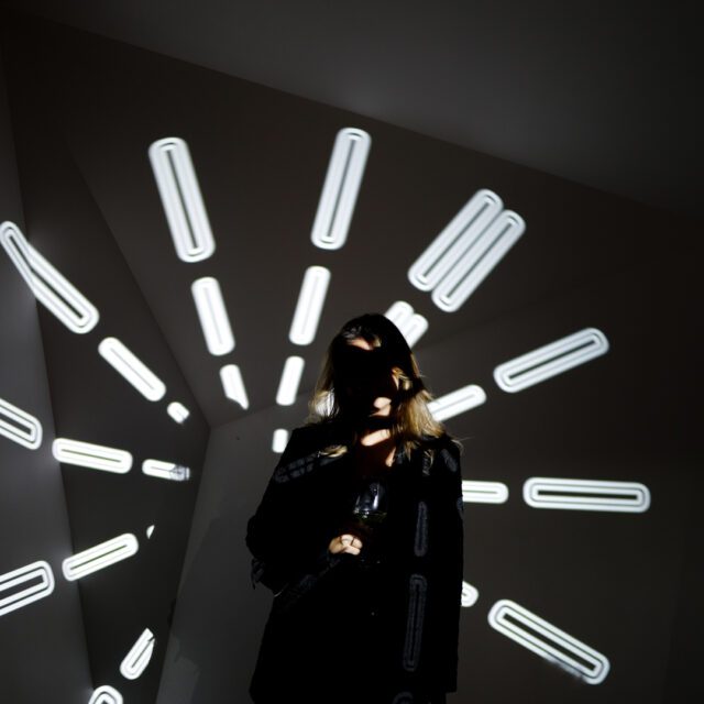 Person vor projizierten Lichtmarkierungen fotografiert von Wuger für ein interaktives Eventdesign mit Fokus auf Zeit und Ästhetik