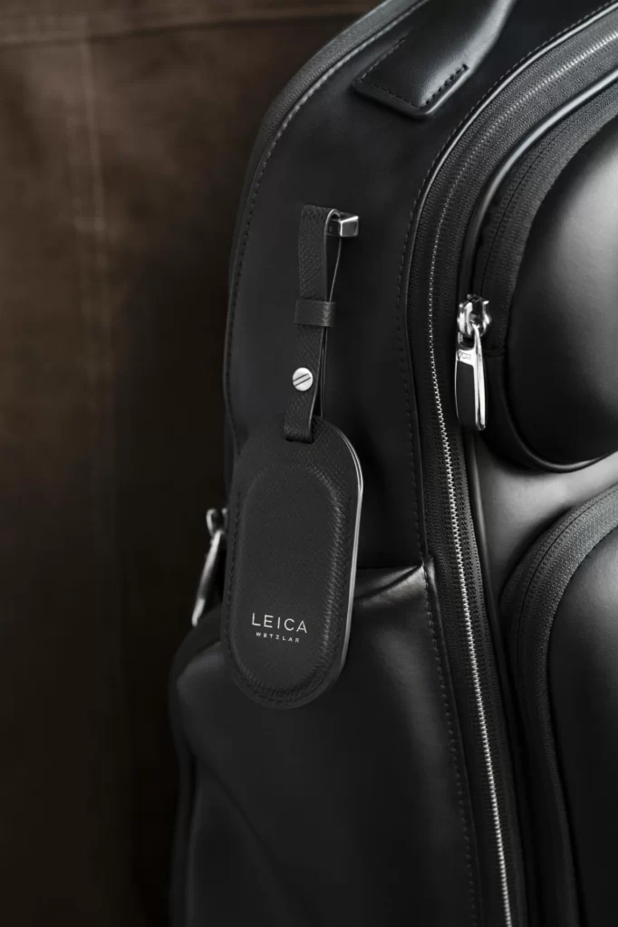 Wuger Launchkampagne Luxusmarke zeigt Leica Leder Gepäckanhänger an schwarzer Tasche mit feiner Verarbeitung