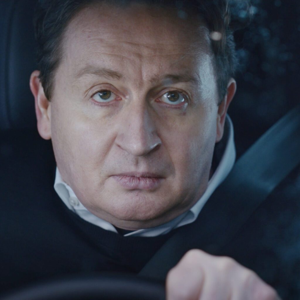 Close-Up von Schauspieler in Auto vermittelt Spannung in Werbefilm von Wuger