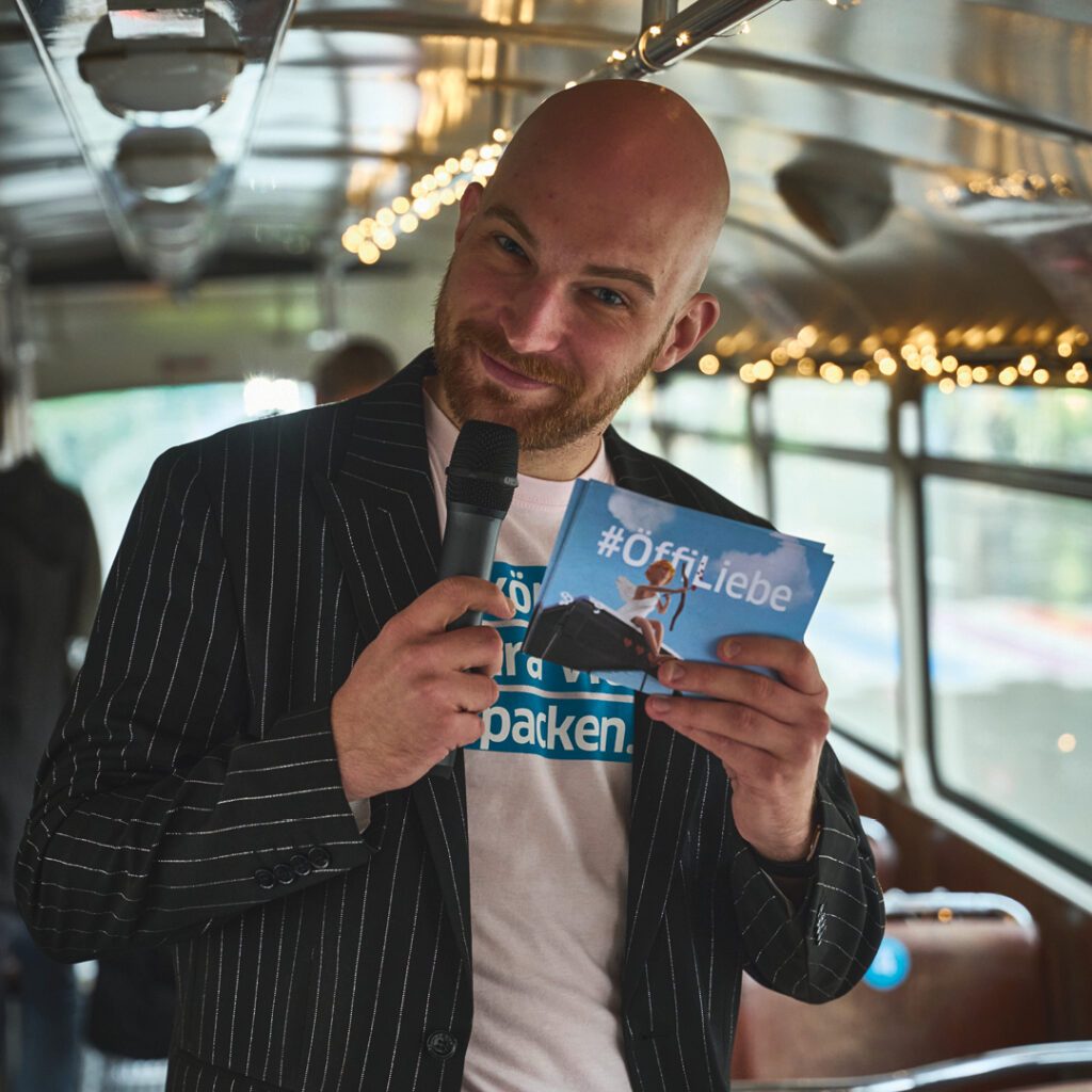 Mit lebendiger Moderation wird das Speeddating Event zu einem Event für echte Begegnungen. Moderator bei Speeddating Live Event von Wuger im Bus mit direkter Einbindung der Teilnehmenden