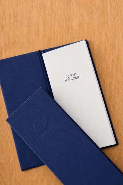 Gestaltete Speisekarte mit geprägtem Logo und markenkonformem Wording im Rahmen des Corporate Designs für ein Businesshotel